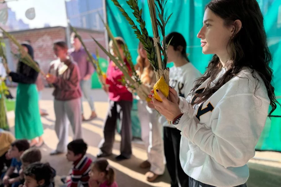 teens shakin lulav and etrog in sukkah